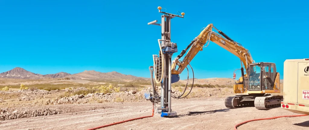 Mincon drill mast attachment for solar mounted on a CAT excavator drilling pile foundations at a utility-scale solar construction site