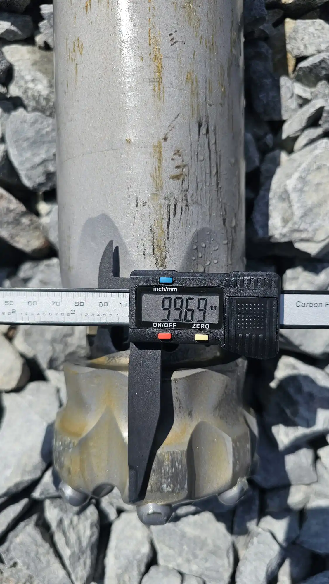 Digital calipers measuring wear on a Mincon DTH hammer to monitor wear and extend hammer life in blast-hole drilling